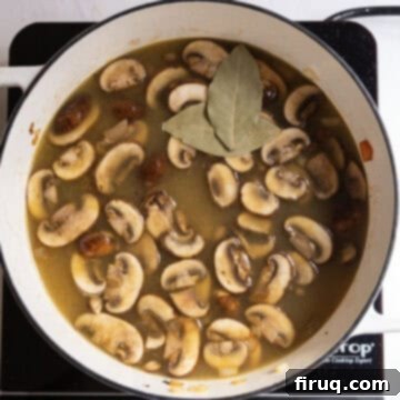Creamy Chicken Tortellini Bliss 9 Chicken broth simmering in the pot with bay leaves and sauteed vegetables.