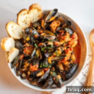 Devilishly Delicious Mussels 12 Mussels Fra Diavolo in a serving bowl with crostini.