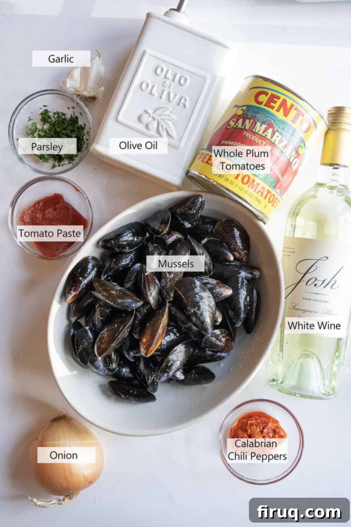 Devilishly Delicious Mussels 3 A vibrant selection of fresh ingredients laid out on a kitchen counter, including fresh mussels, plum tomatoes, onion, garlic, and Calabrian chili peppers, ready for making Mussels Fra Diavolo.