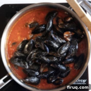Devilishly Delicious Mussels 8 Fresh mussels added to the simmering spicy tomato sauce in a pan, covered and ready for steaming to perfection.
