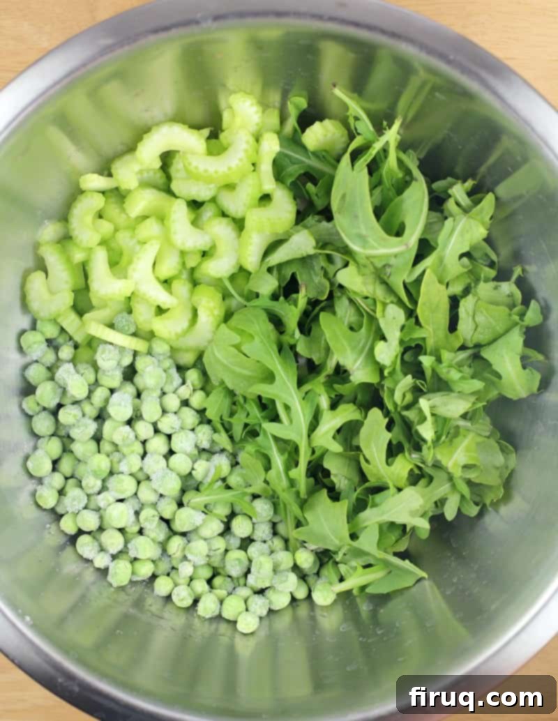 Spring Potato Salad with Zesty Dill 6 Fresh celery, green peas, and vibrant arugula leaves in a metal mixing bowl.