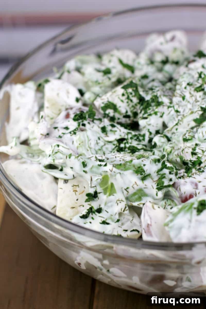 Spring Potato Salad with Zesty Dill 9 Spring potato salad with dill in a decorative bowl on a rustic wood surface, ready to be served.