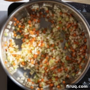 Rustic Italian Lentils 4 Carrots, onion, and celery sauteing in a saucepan.