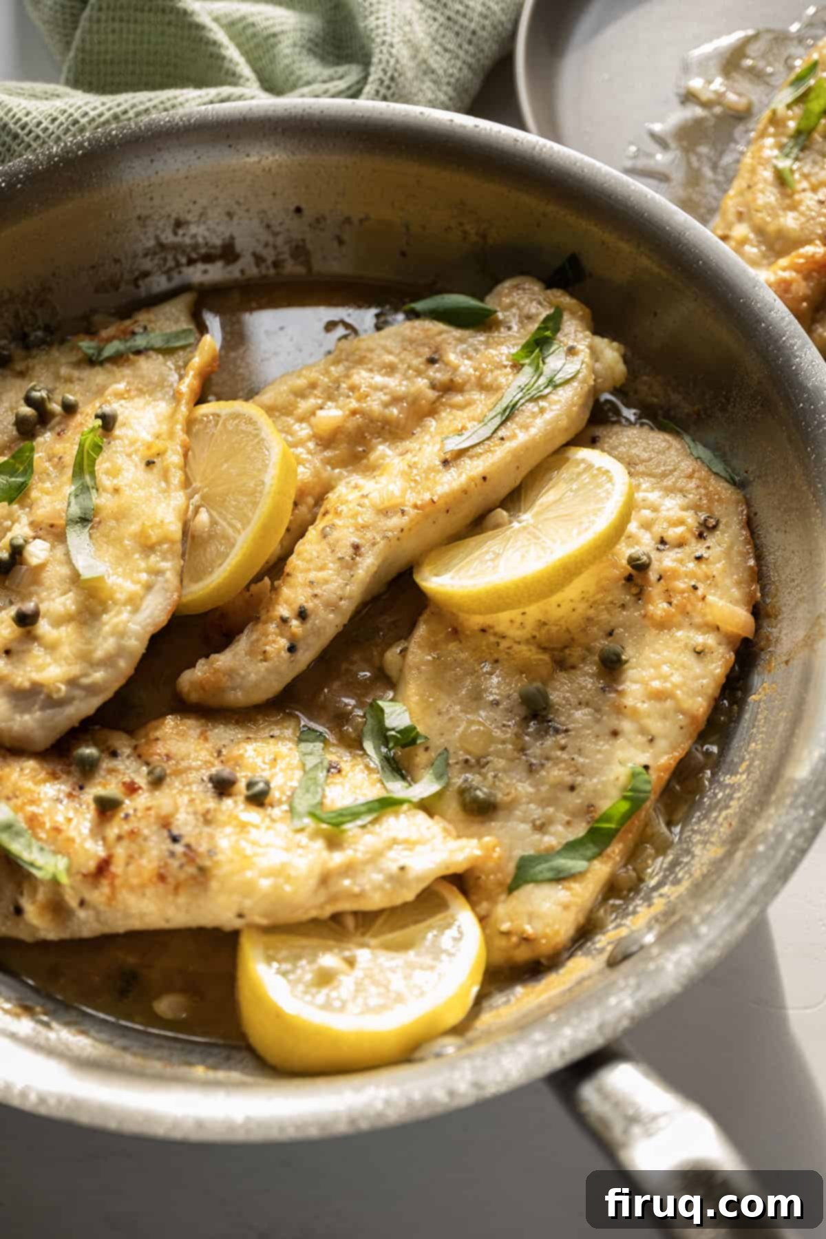 Perfect Homemade Chicken Piccata 2 Chicken piccata in a saucepan with lemon and basil.