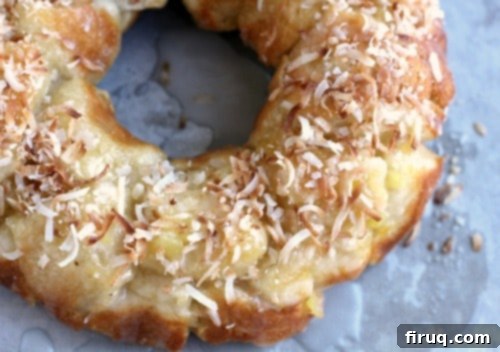 Tropical Pina Colada Pull-Apart Bread 2 Close-up view of the golden-brown Pina Colada Monkey Bread, glistening with glaze and ready to be served on a baking sheet.