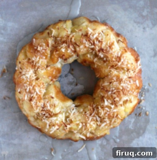 Tropical Pina Colada Pull-Apart Bread 8 Top-down view of the beautifully golden Pina Colada Monkey Bread on a rustic baking sheet, glistening with its glaze.