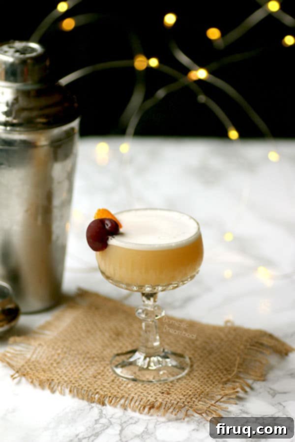 Foamy Amaretto Sour Cocktail Amaretto Sour Cocktail with a thick foam and a cherry garnish.