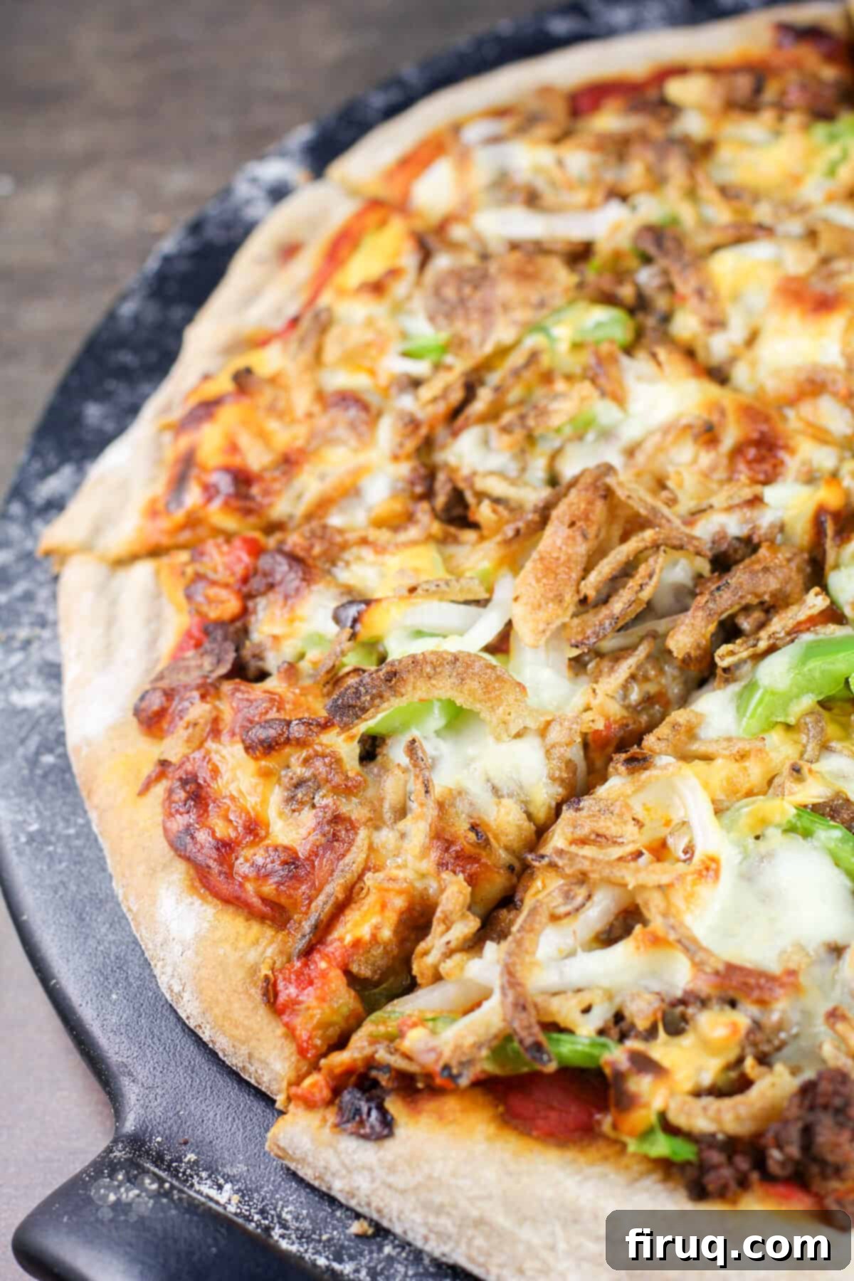 Chili Cheeseburger Pizza 7 sliced pizza on black pizza stone