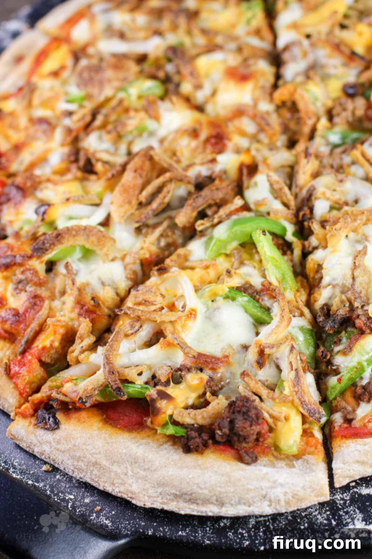 Chili Cheeseburger Pizza 8 sliced pizza on black pizza stone