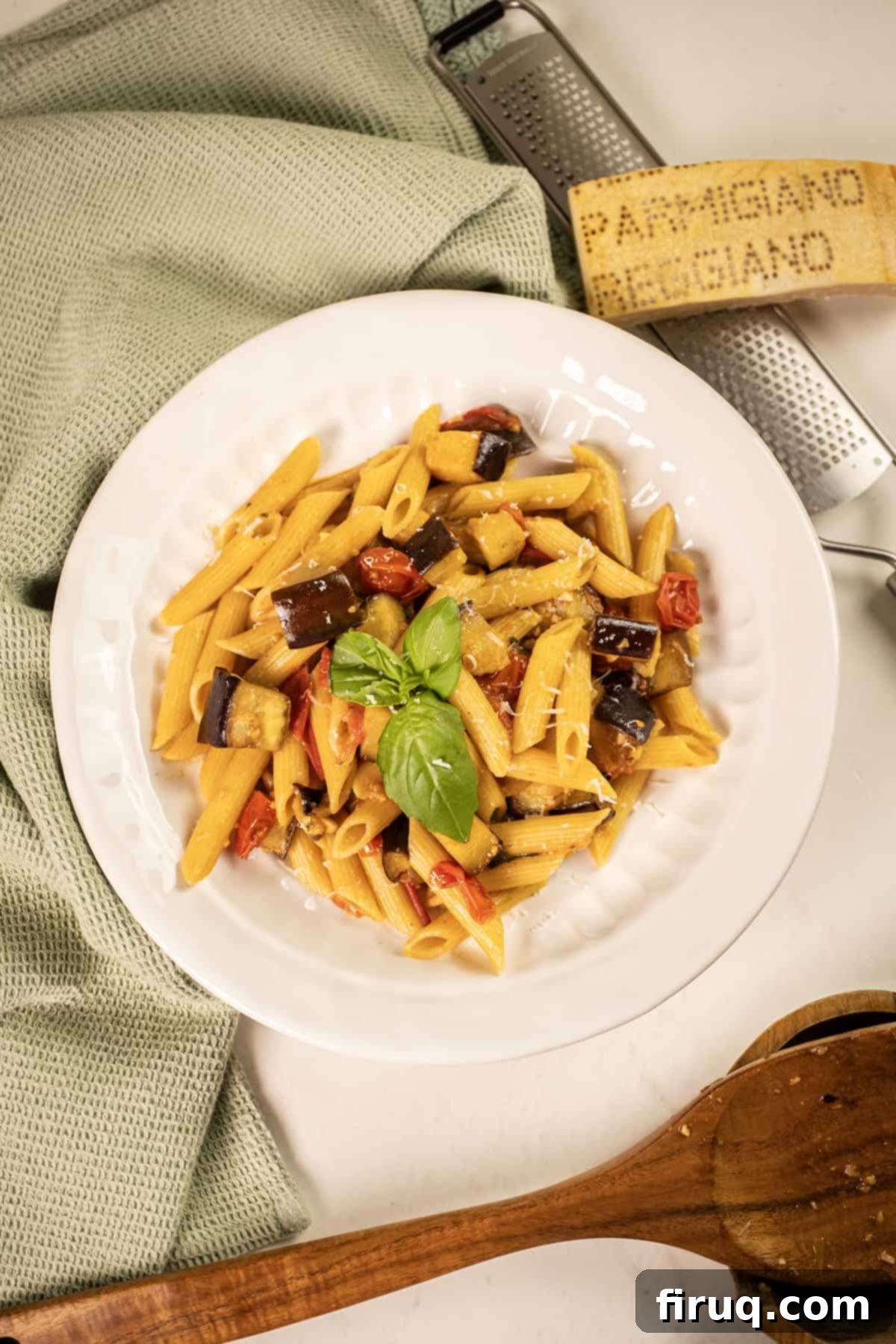 Effortless Eggplant and Tomato Pasta 2 Pasta with eggplant and cherry tomatoes in a bowl garnished with fresh basil.