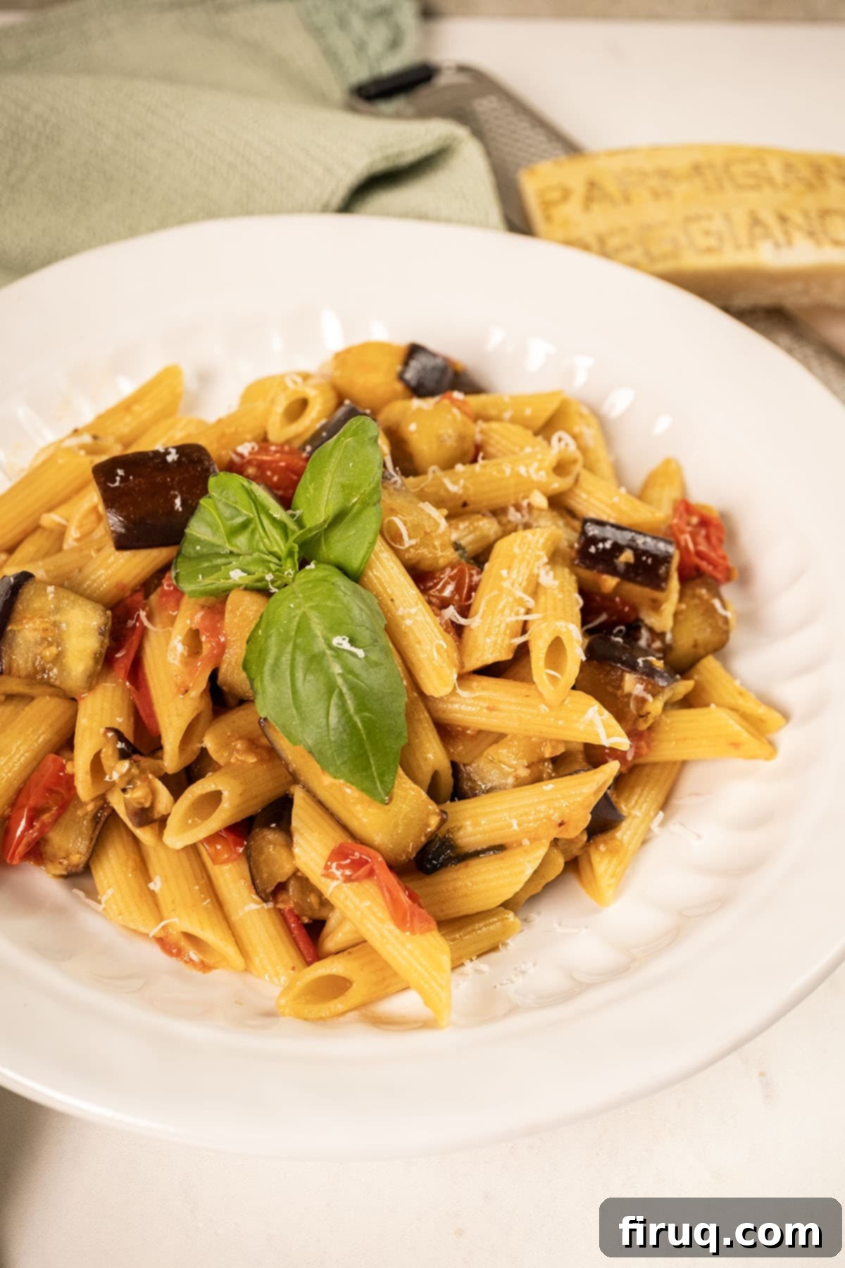 Effortless Eggplant and Tomato Pasta 12 Pasta with eggplant and cherry tomatoes in a bowl garnished with fresh basil.