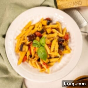 Effortless Eggplant and Tomato Pasta 13 Pasta with eggplant and cherry tomatoes in a bowl garnished with fresh basil.