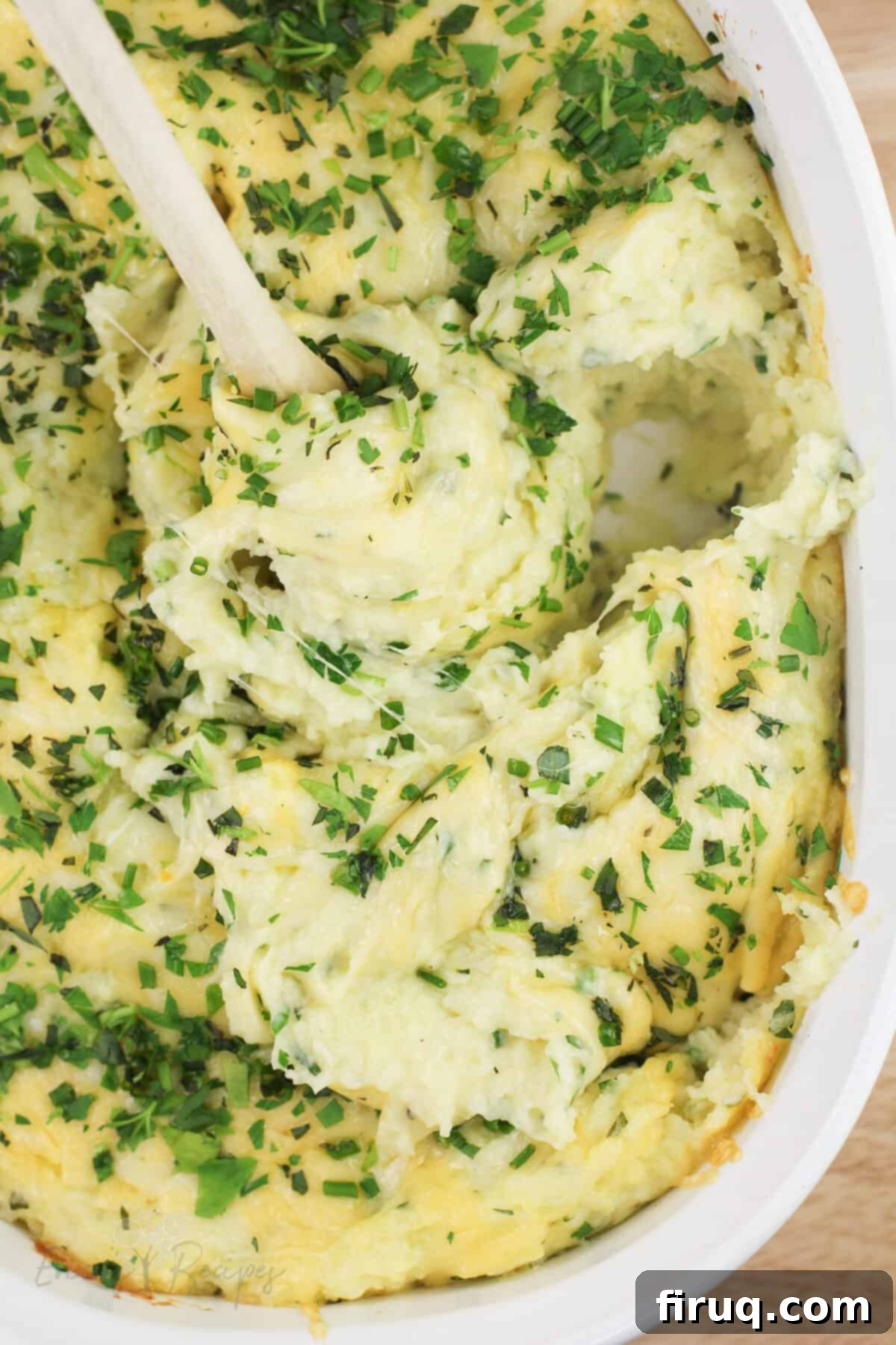 Garlicky Gruyere and Gouda Mashed Potatoes 14 spoon stirring prepared recipe topped with French fine herbs