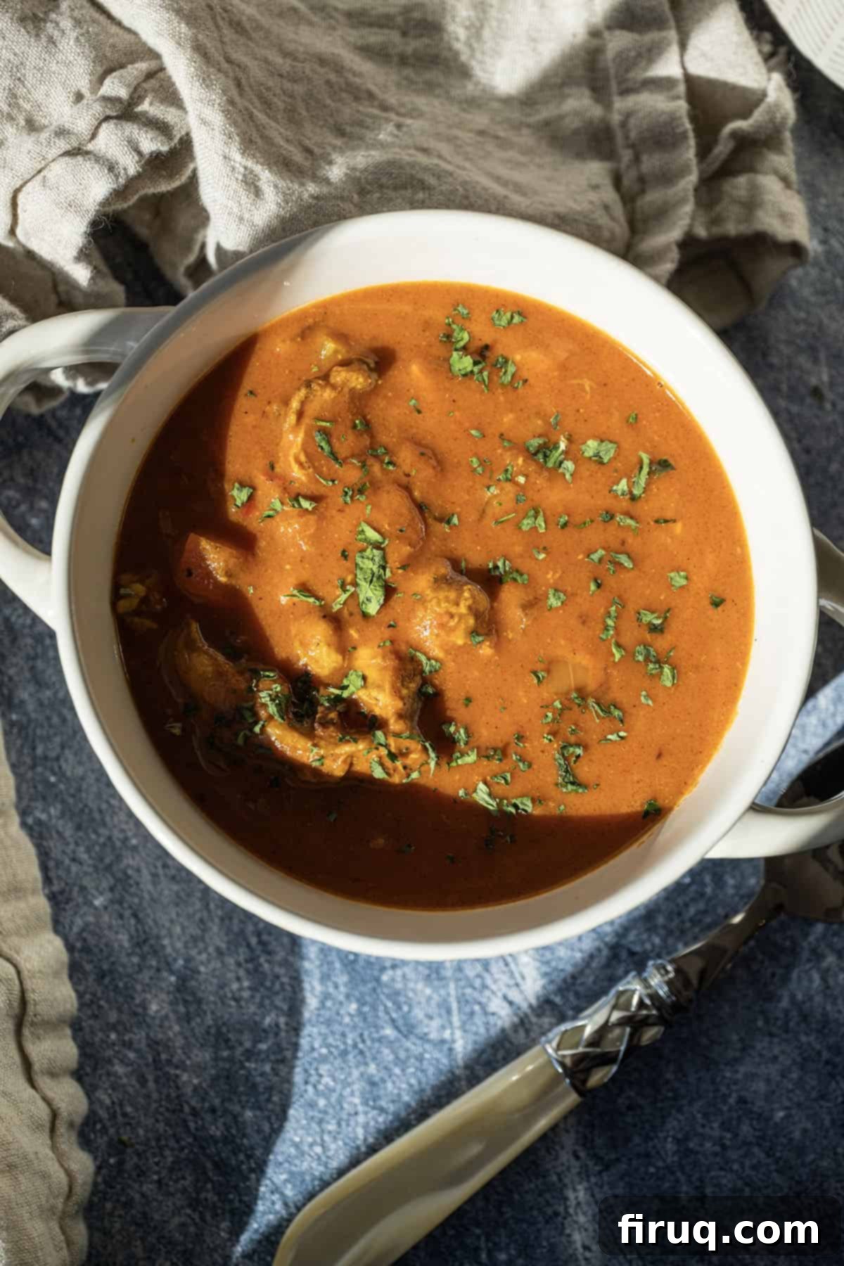 Golden Butter Chicken Comfort 11 Butter chicken soup in a bowl topped with cilantro.