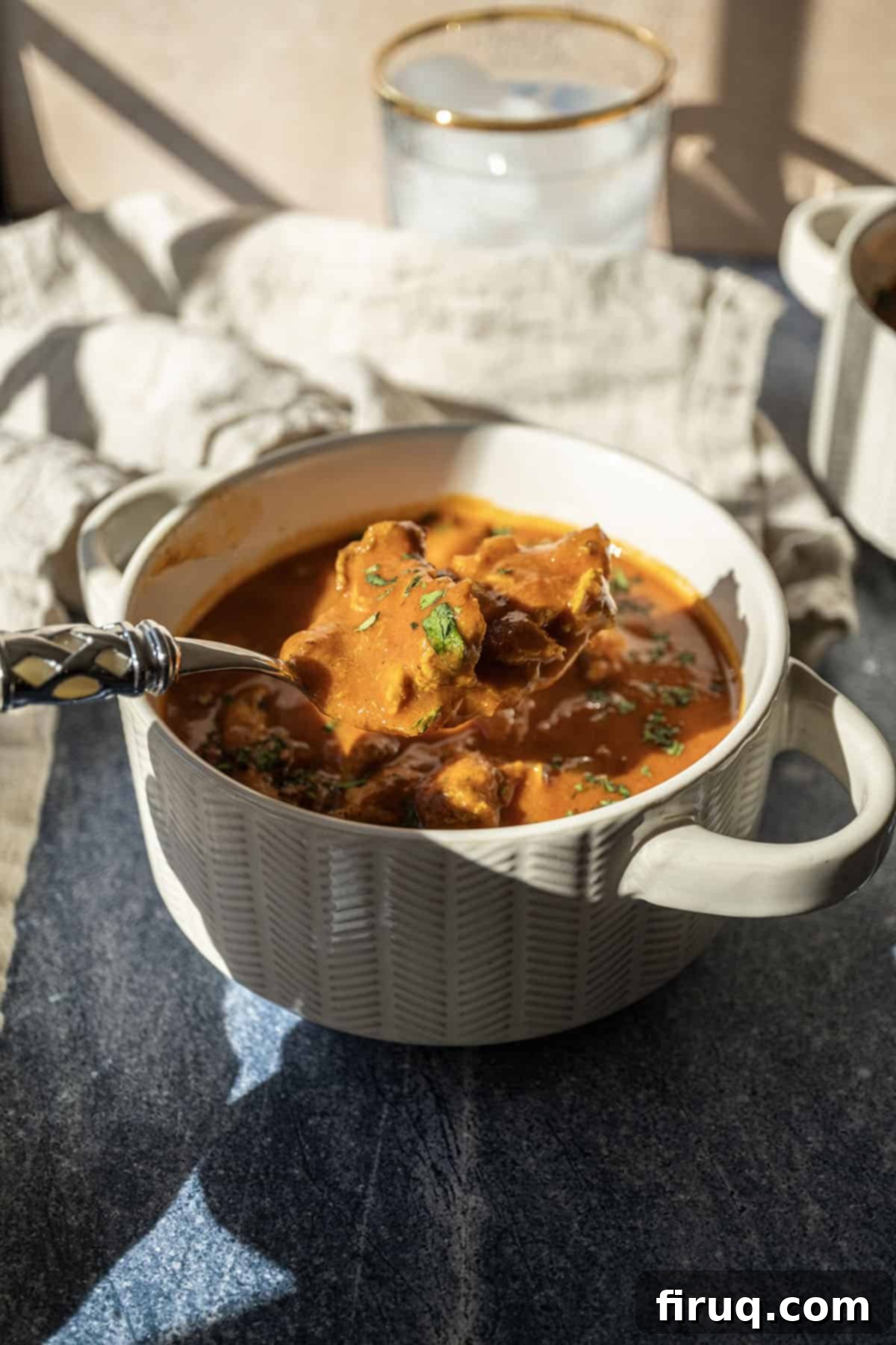 Golden Butter Chicken Comfort 12 Butter chicken soup in a bowl topped with cilantro.