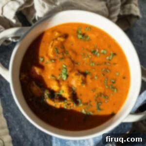 Golden Butter Chicken Comfort 13 Butter chicken soup in a bowl topped with cilantro.