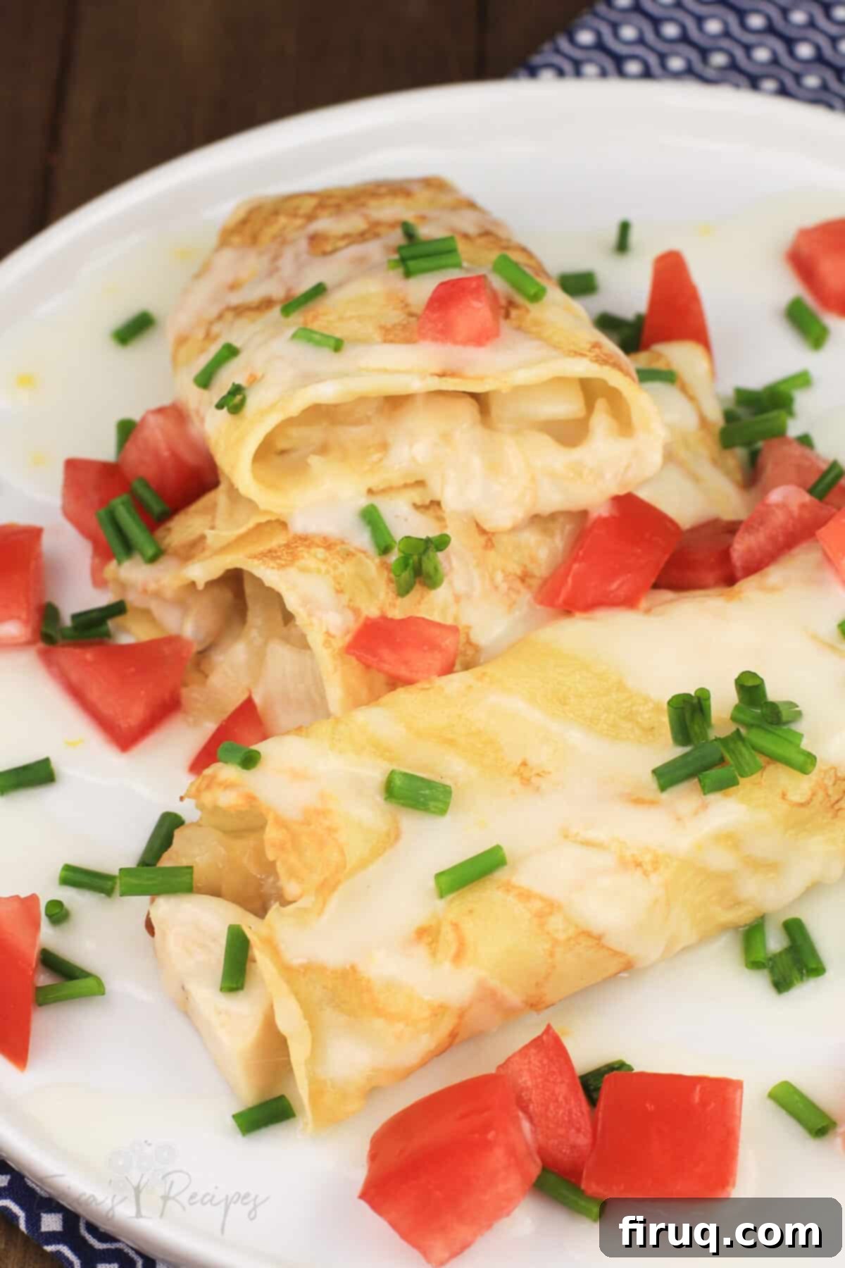 Golden Chicken Potato Crepe Parcels 2 crepes with chicken and potato on white plate, one cut open to show filling
