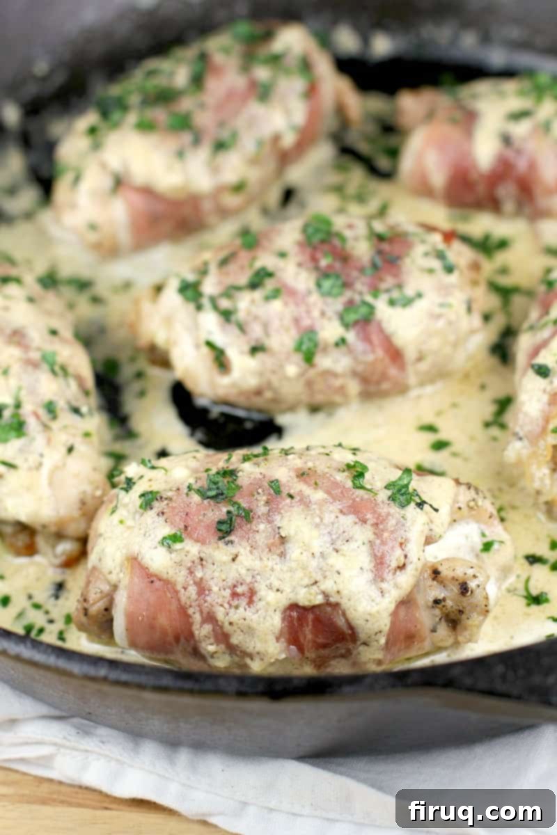 Gourmet Prosciutto-Wrapped Boursin Chicken 9 cooked chicken in a skillet with sauce