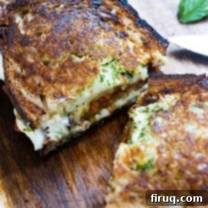 Ultimate Caprese Eggplant Melt 8 A perfectly golden-brown Eggplant Caprese Grilled Cheese, cut in half to reveal the gooey melted cheese, grilled eggplant, roasted tomatoes, and pesto inside.