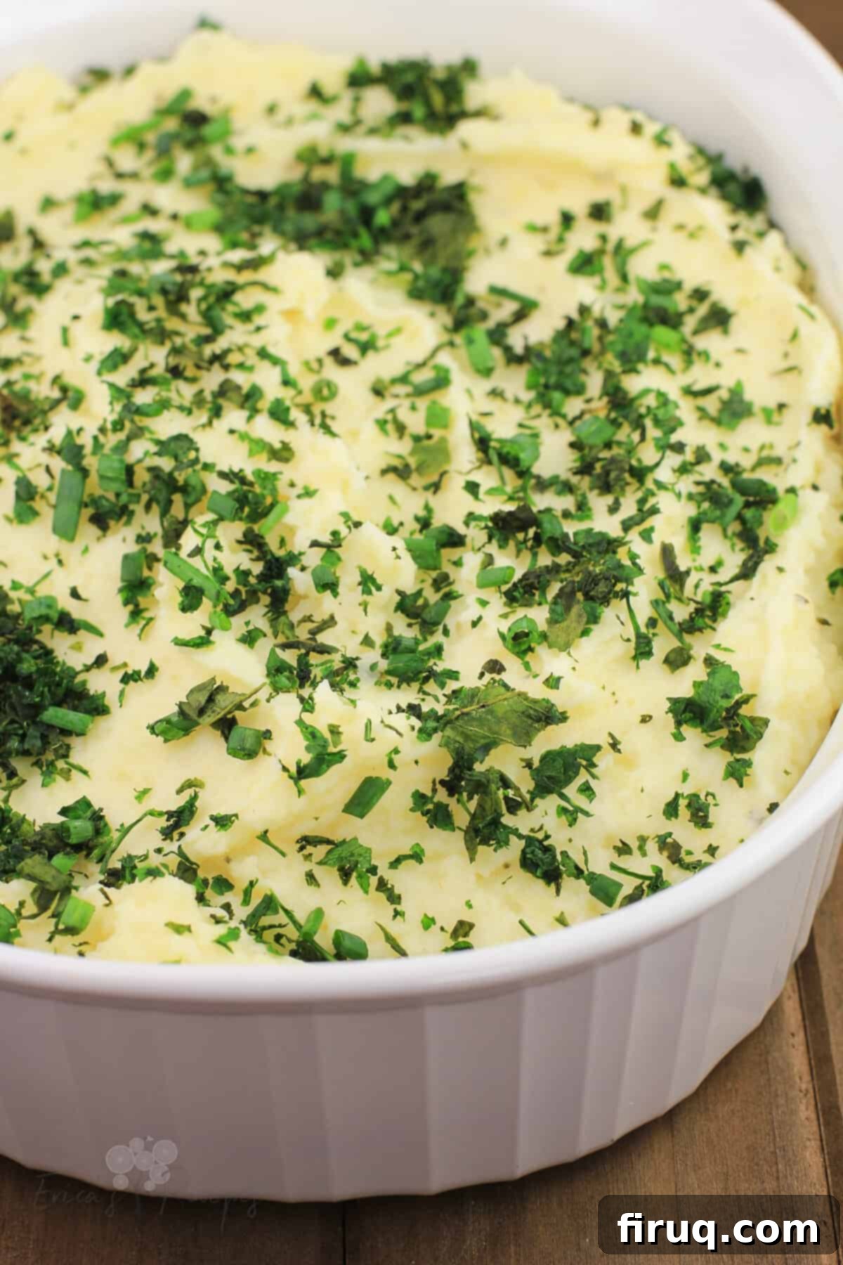 Decadent Boursin Mashed Potatoes 2 boursin mashed potatoes in white bake dish topped with herbs