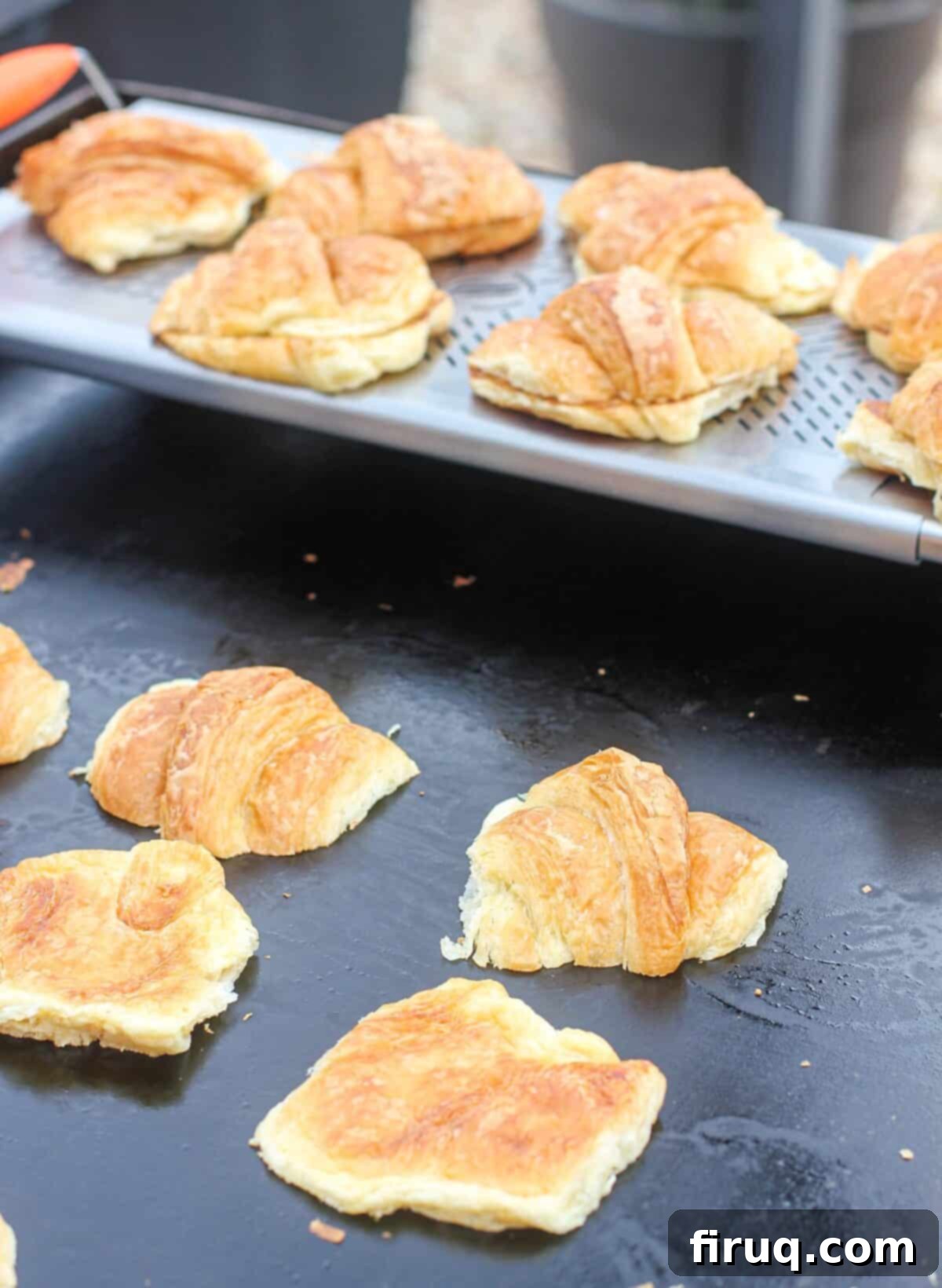 Blackstone Croissant Breakfast Melts 4 croissants toasting on Blackstone griddle top; warmer rack in the background