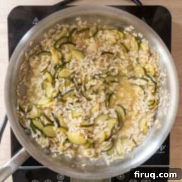 Creamy Zucchini Risotto 9 Chicken broth fully absorbing into the rice, creating a creamy texture.