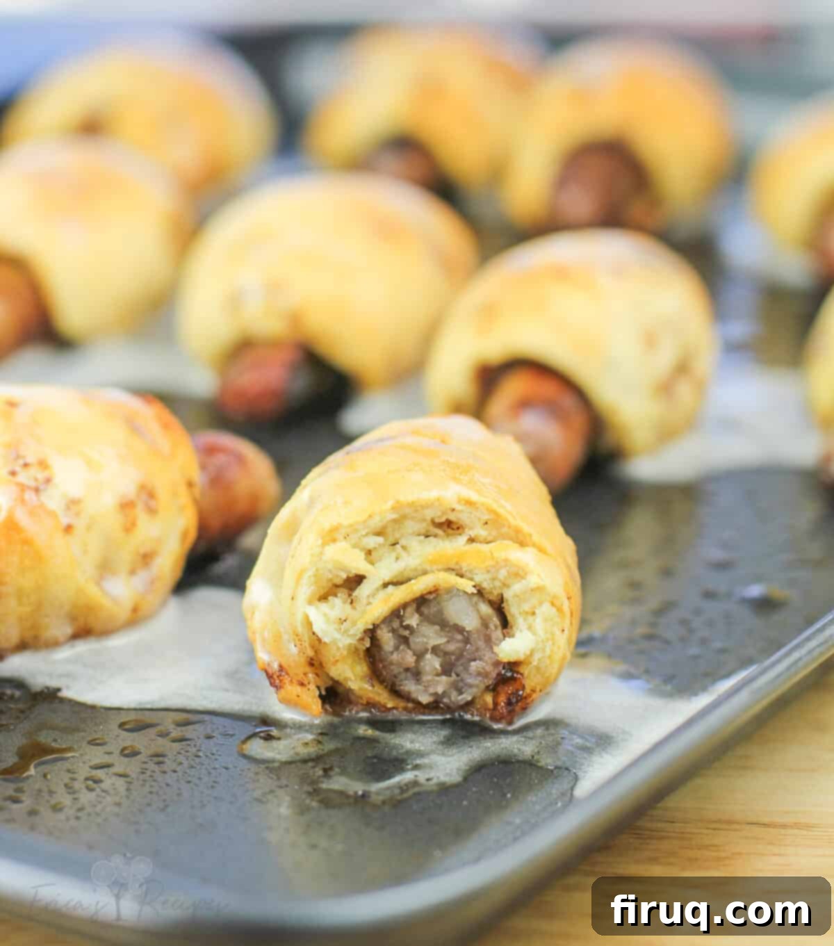 Cinnamon Swirl Sausage Bites 3 Close-up view of a cooked Cinnamon Roll Pig in a Blanket, cut in half to show the sausage inside.