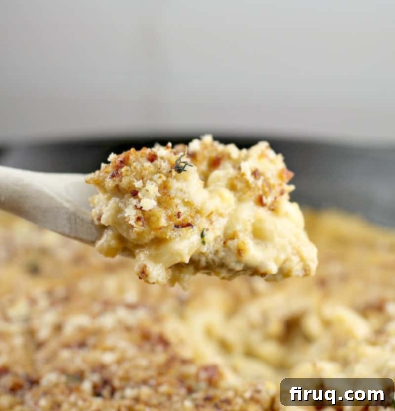 Beer-Infused Bacon Garlic Mac & Cheese 11 side view of a wooden spoon scooping up a bit of the beer mac and cheese