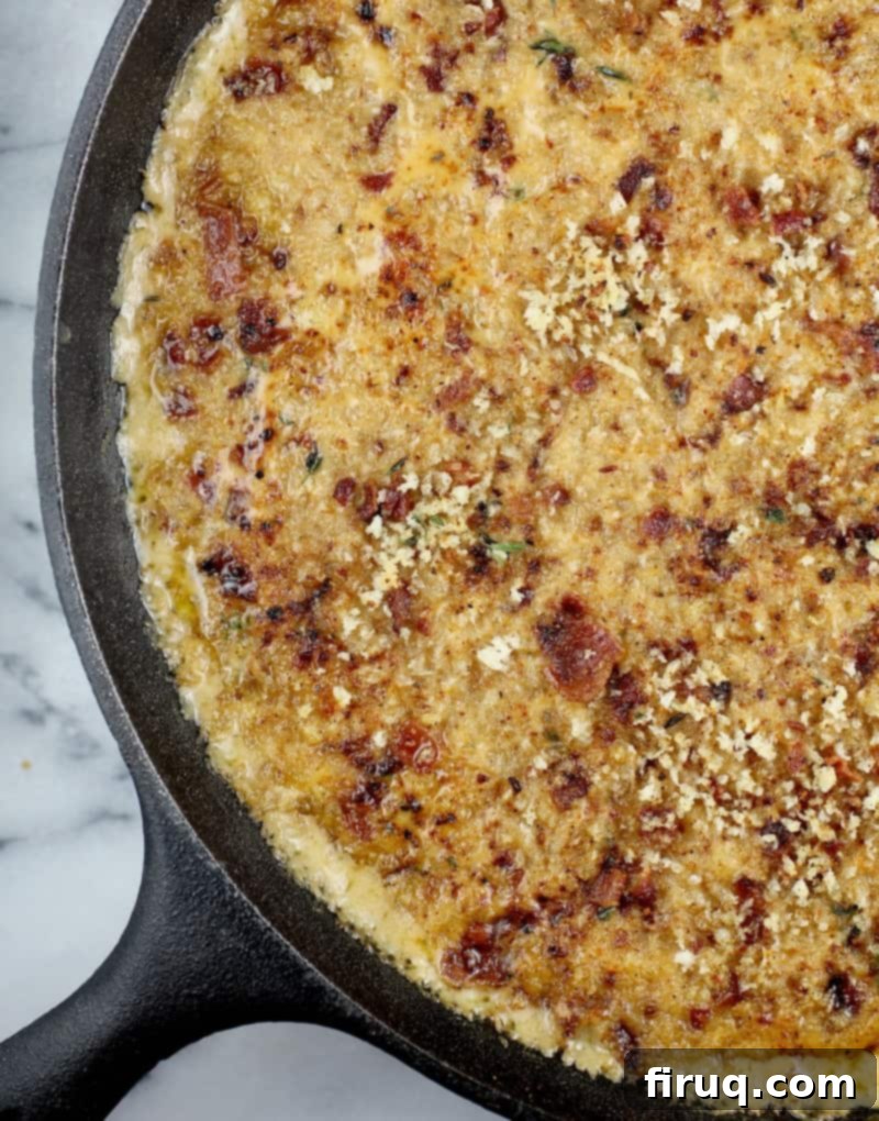 Beer-Infused Bacon Garlic Mac & Cheese 12 top down view of the cooked bacon macaroni and cheese in a large cast iron skillet