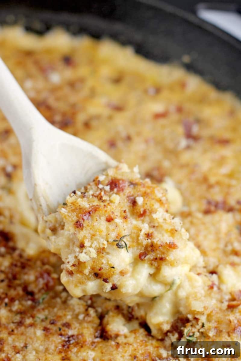 Beer-Infused Bacon Garlic Mac & Cheese 3 side view of a wooden spoon scooping up a bit of the beer mac and cheese