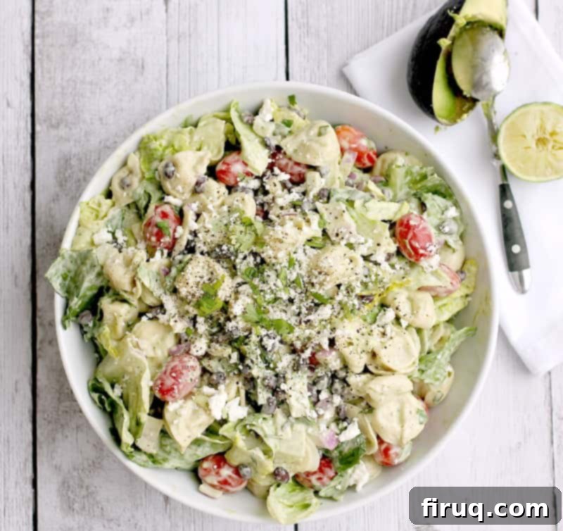 Creamy Avocado Tortellini Salad 2 A vibrant and colorful tortellini salad with creamy avocado dressing, viewed from above in a large serving bowl, ready for a potluck