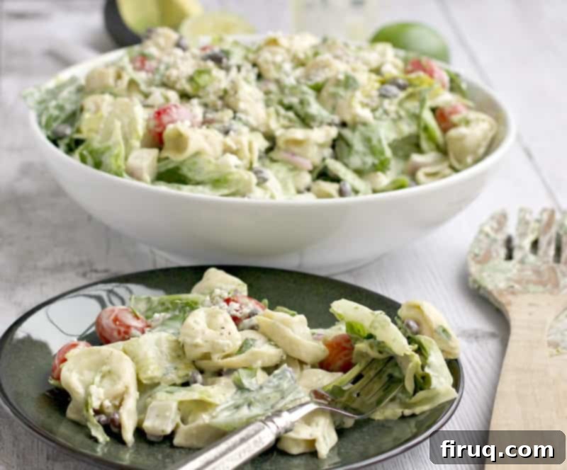 Creamy Avocado Tortellini Salad 6 A perfectly portioned serving of the tortellini salad with avocado dressing on a green plate, accompanied by a fork, ready to be enjoyed as a meal or side dish