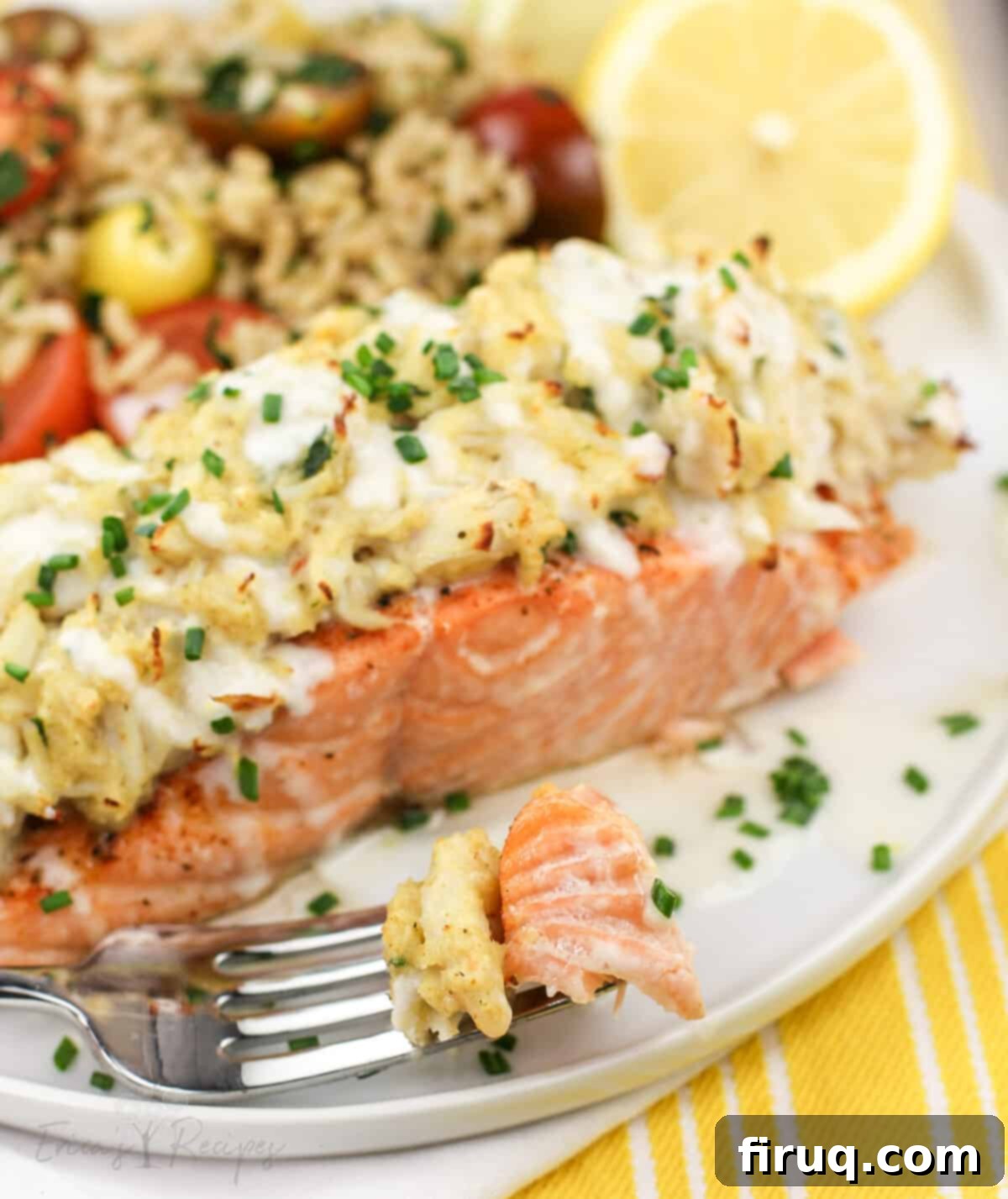 Gourmet Crab Stuffed Salmon 8 fork on white plate holding bite of salmon and stuffing next to large piece of salmon