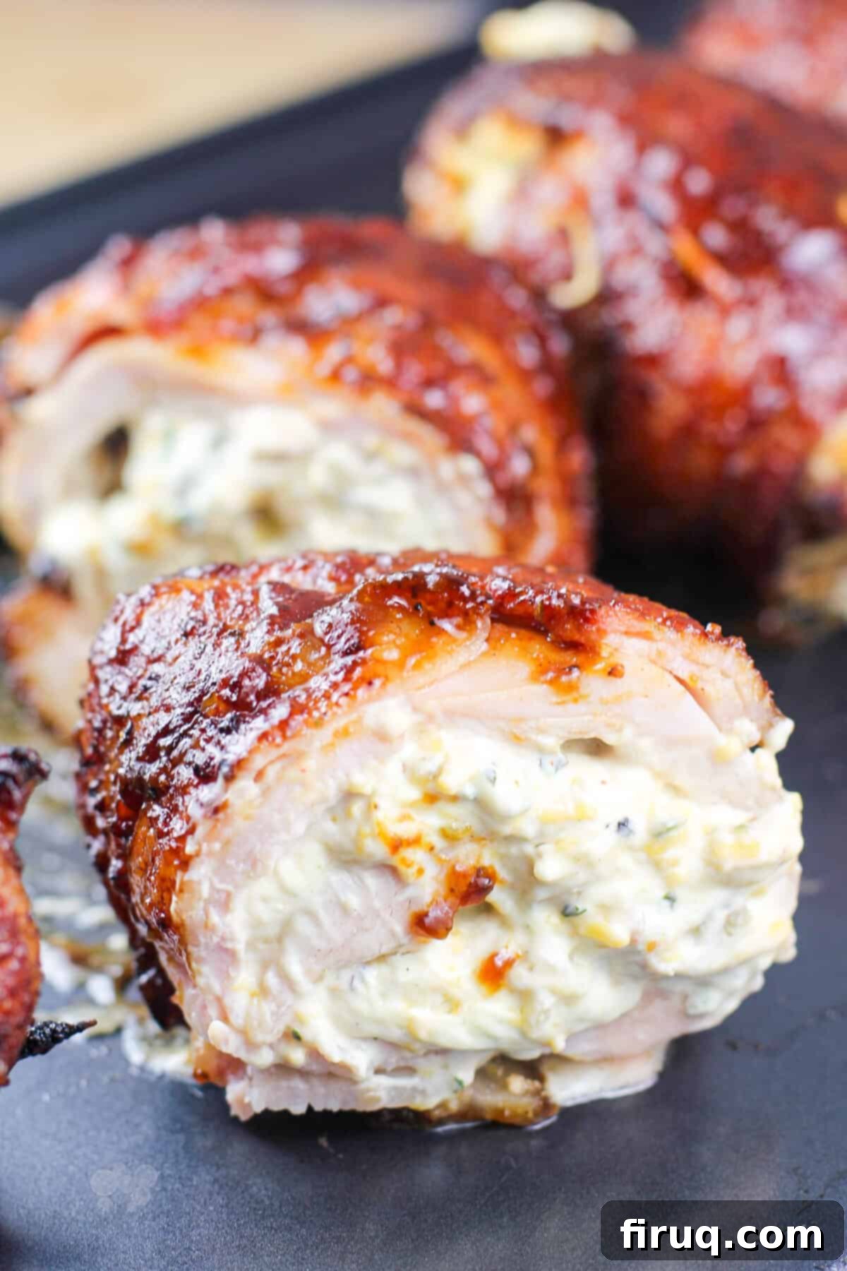 Smoky Jalapeno Chicken Poppers 6 Close-up cross-section of a Smoked Jalapeno Stuffed Chicken Bomb on a baking sheet, showing the melted cheese, jalapeno, and tender chicken meat.