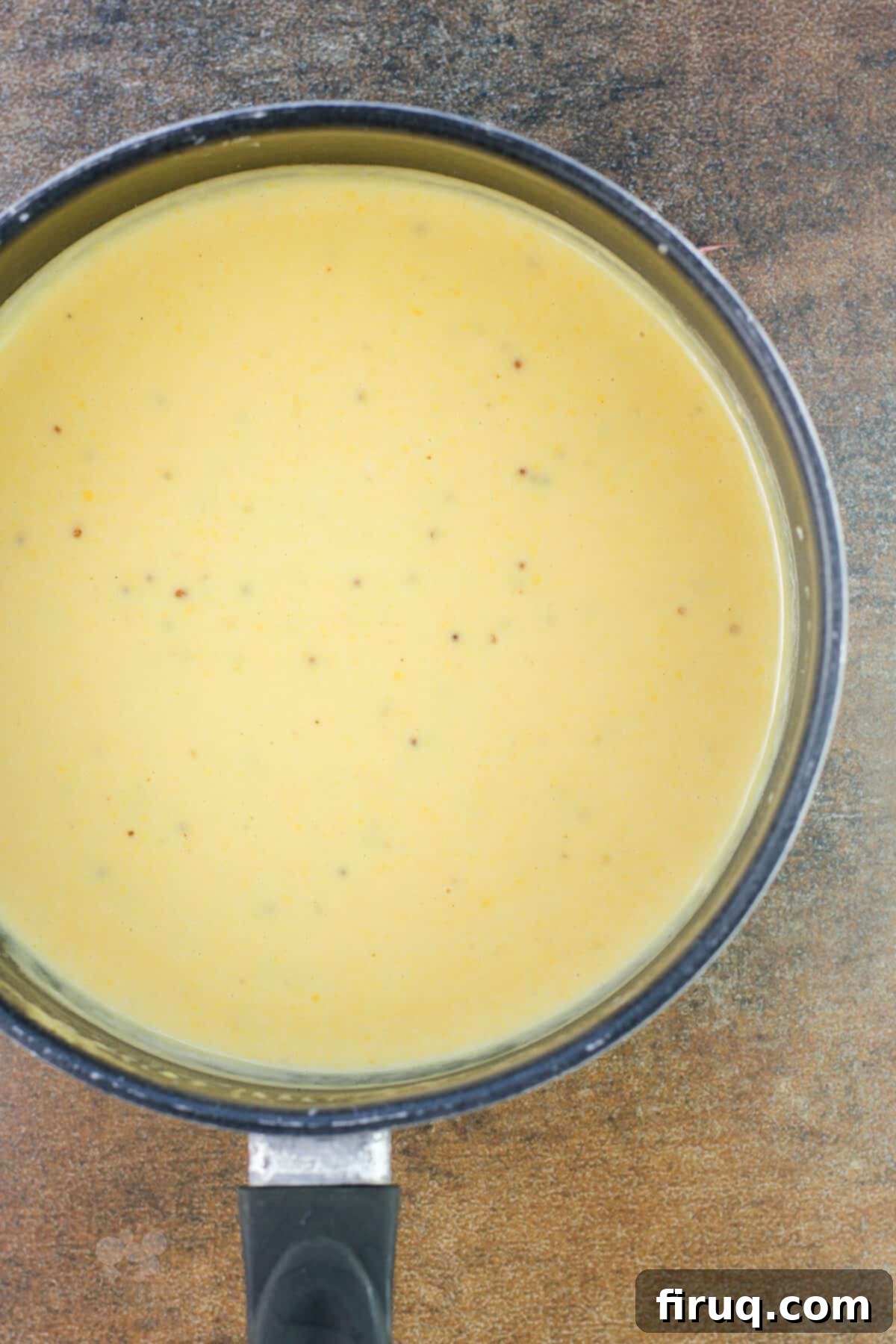 Traditional German Beer Cheese 4 saucepan with beer cheese on brown background