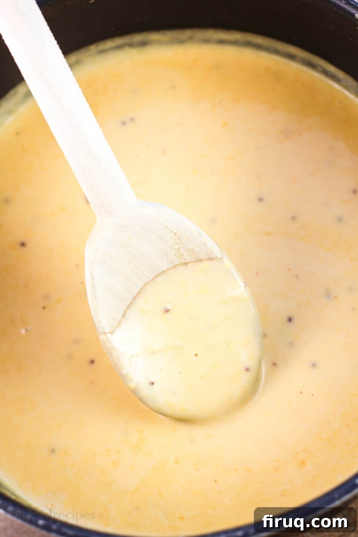 Traditional German Beer Cheese 5 wood spoon in beer cheese in saucepan