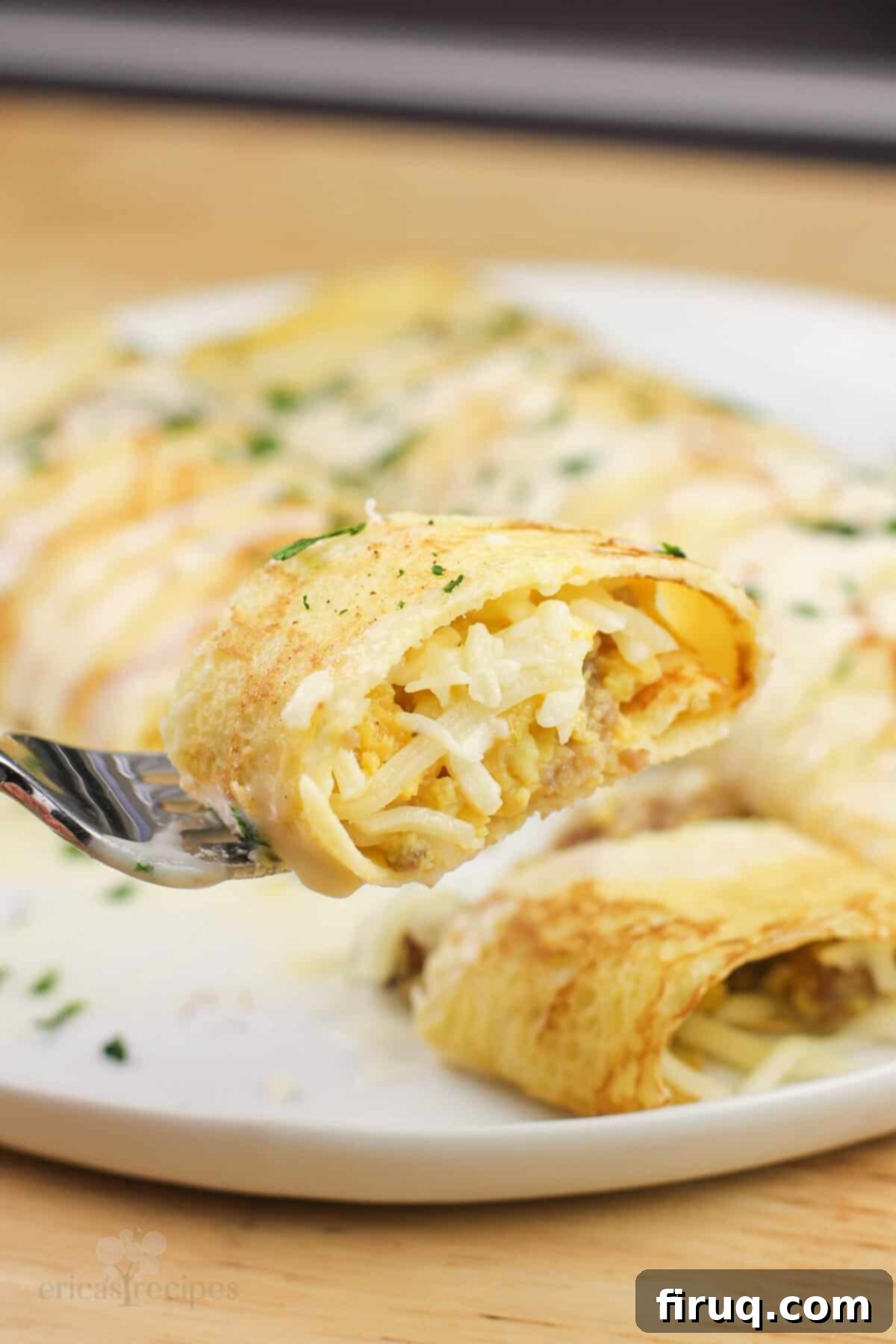 Sweet & Savory Sausage Crepes with Maple Béchamel 9 piece of prepared recipe on fork over white plate