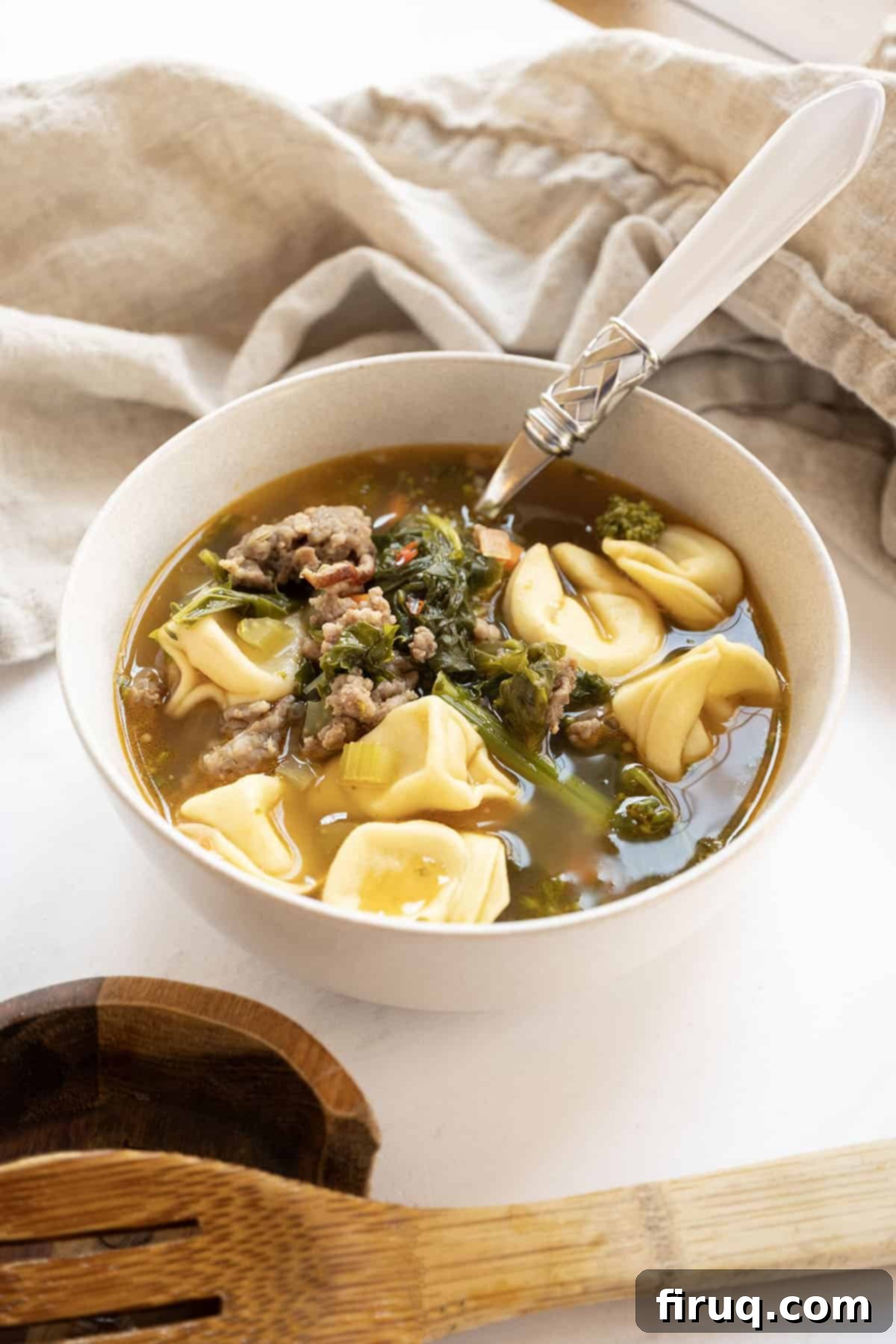 Savory Broccoli Rabe & Tortellini Bowl 11 A close-up of a bowl of Broccoli Rabe and Tortellini Soup with Sausage, garnished with fresh Parmesan, ready to be enjoyed.
