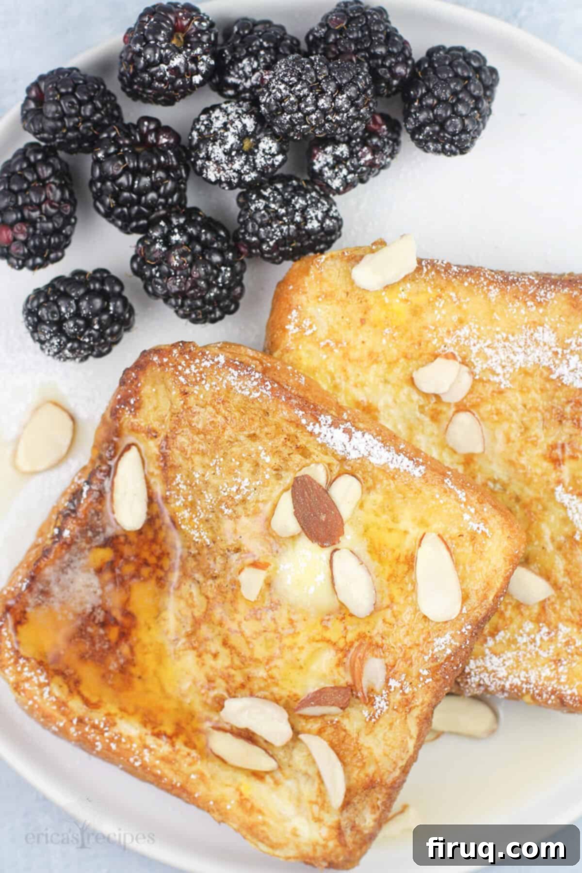 Blackstone Amaretto French Toast 3 Close-up of fluffy French toast slices on a white plate, garnished with fresh blackberries, highlighting the delicious texture and presentation.