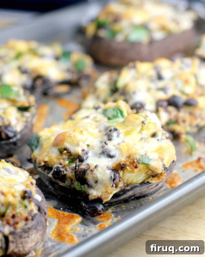 Zesty Mexican Quinoa Portobello Boats 12 cooked mushrooms on a bake sheet topped with cheese