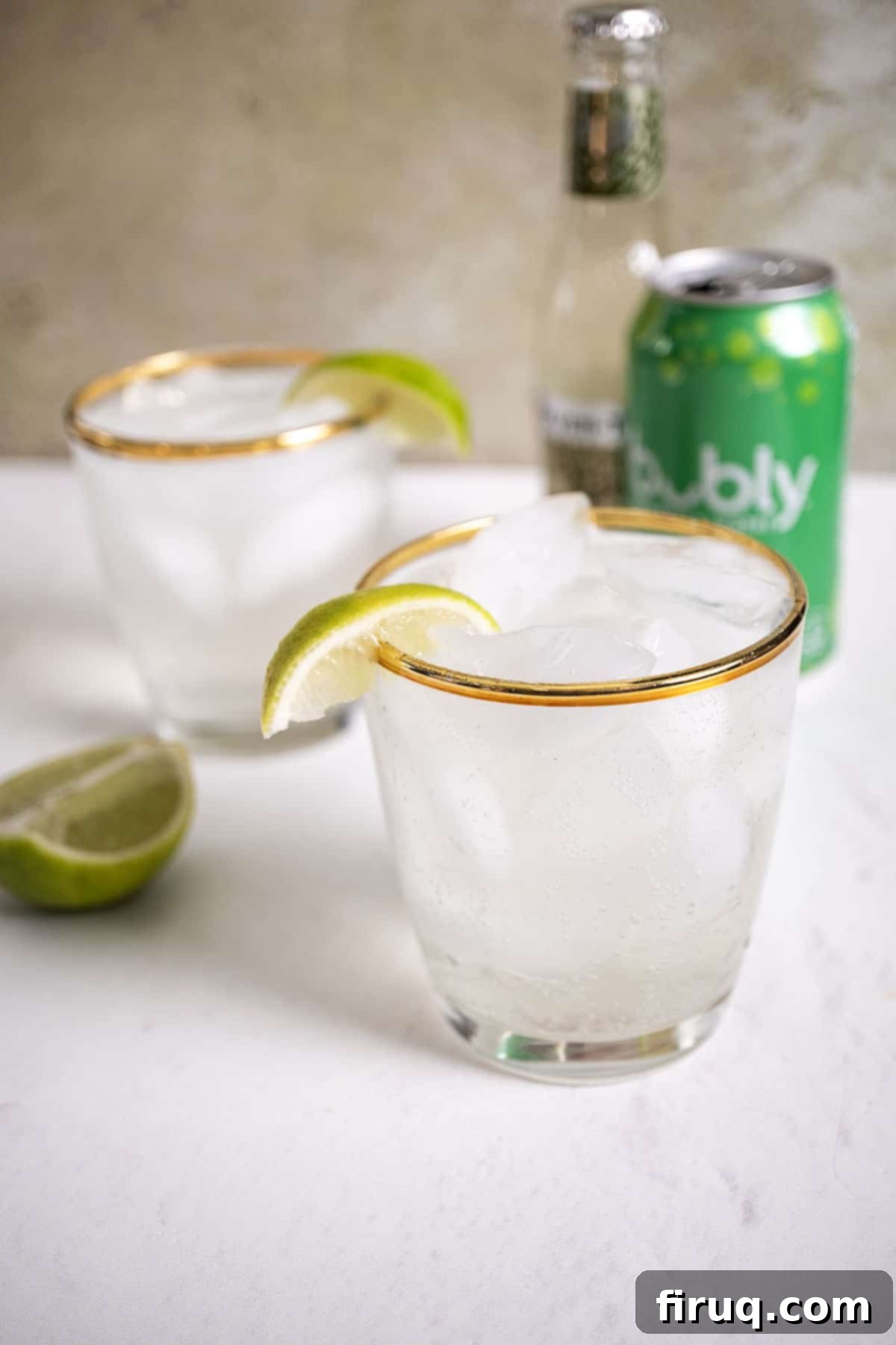 Refreshingly Crisp Alcohol-Free Moscow Mule 2 Two glasses of non-alcoholic Moscow Mules garnished with lime wedges, with a fresh lime and a can of seltzer in the background.