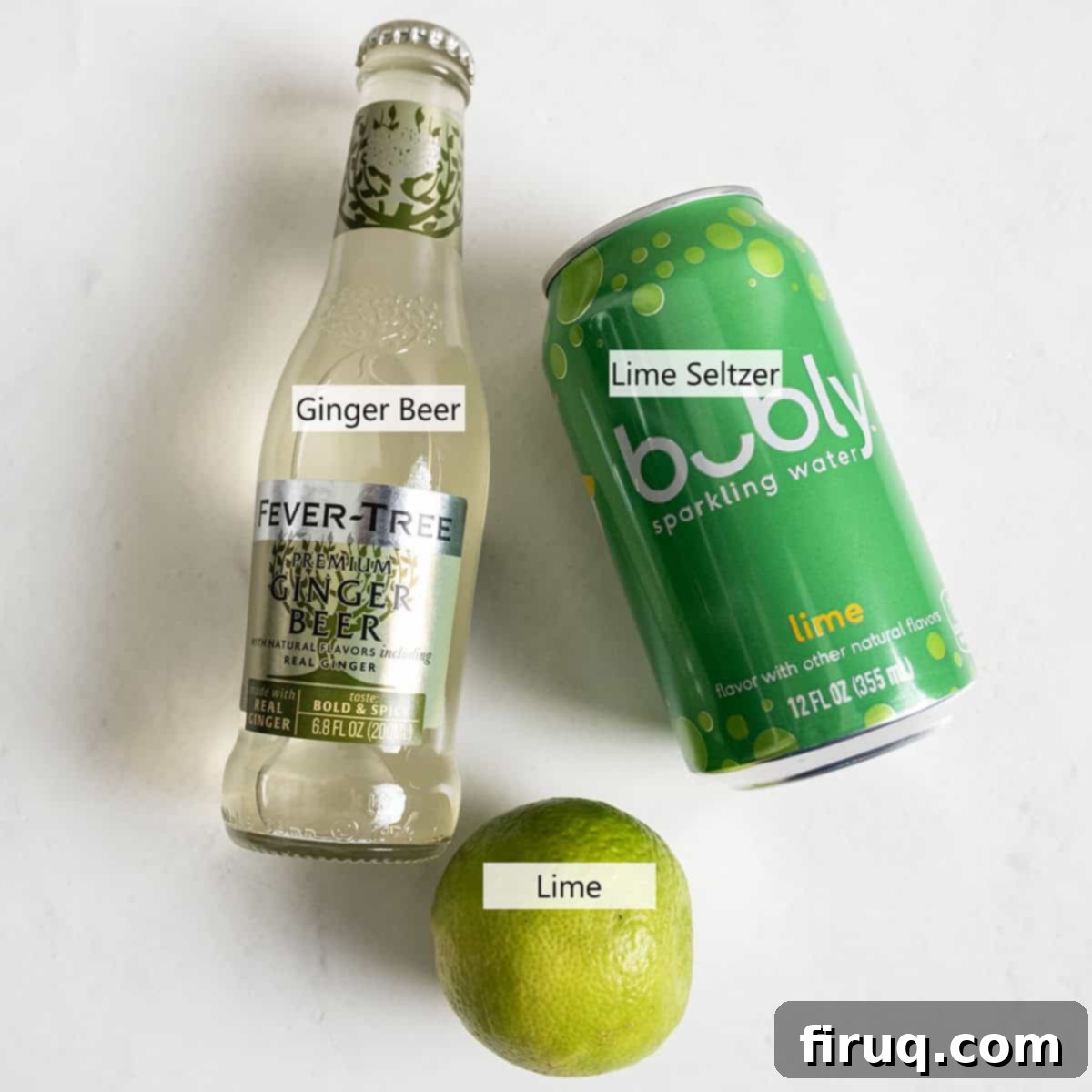 Refreshingly Crisp Alcohol-Free Moscow Mule 3 A flat lay image showing the ingredients for the Non-Alcoholic Moscow Mule: a bottle of ginger beer, a can of lime seltzer, and fresh limes.