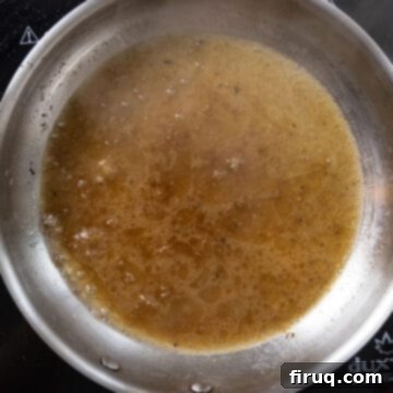 The Ultimate Carbonara Do's and Don'ts 7 Starchy pasta water being added to the rendered guanciale fat in a saucepan to create a sauce base.