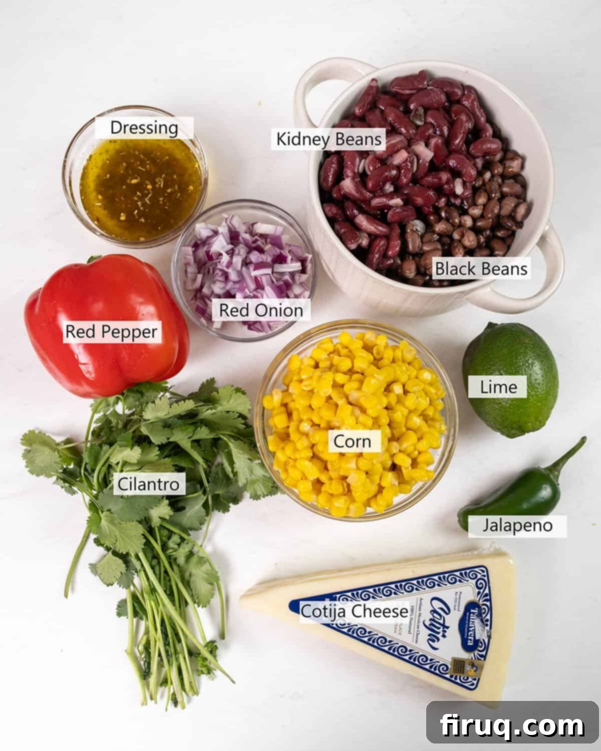 Tex-Mex Treasure Salad 3 A beautifully arranged flat lay of all the fresh ingredients required for a delicious Cowboy Caviar Salad, including canned kidney beans and black beans, sweet corn kernels, bright red bell pepper, thinly sliced red onion, fiery jalapenos, fresh cilantro, zesty lime, rich olive oil, and a selection of savory spices.