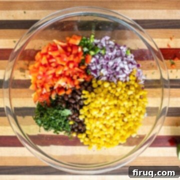 Tex-Mex Treasure Salad 4 Mixed black beans, kidney beans, sweet corn, and freshly chopped vegetables including vibrant red bell pepper, zesty red onion, and a hint of jalapeno combined in a large mixing bowl, ready for the dressing.