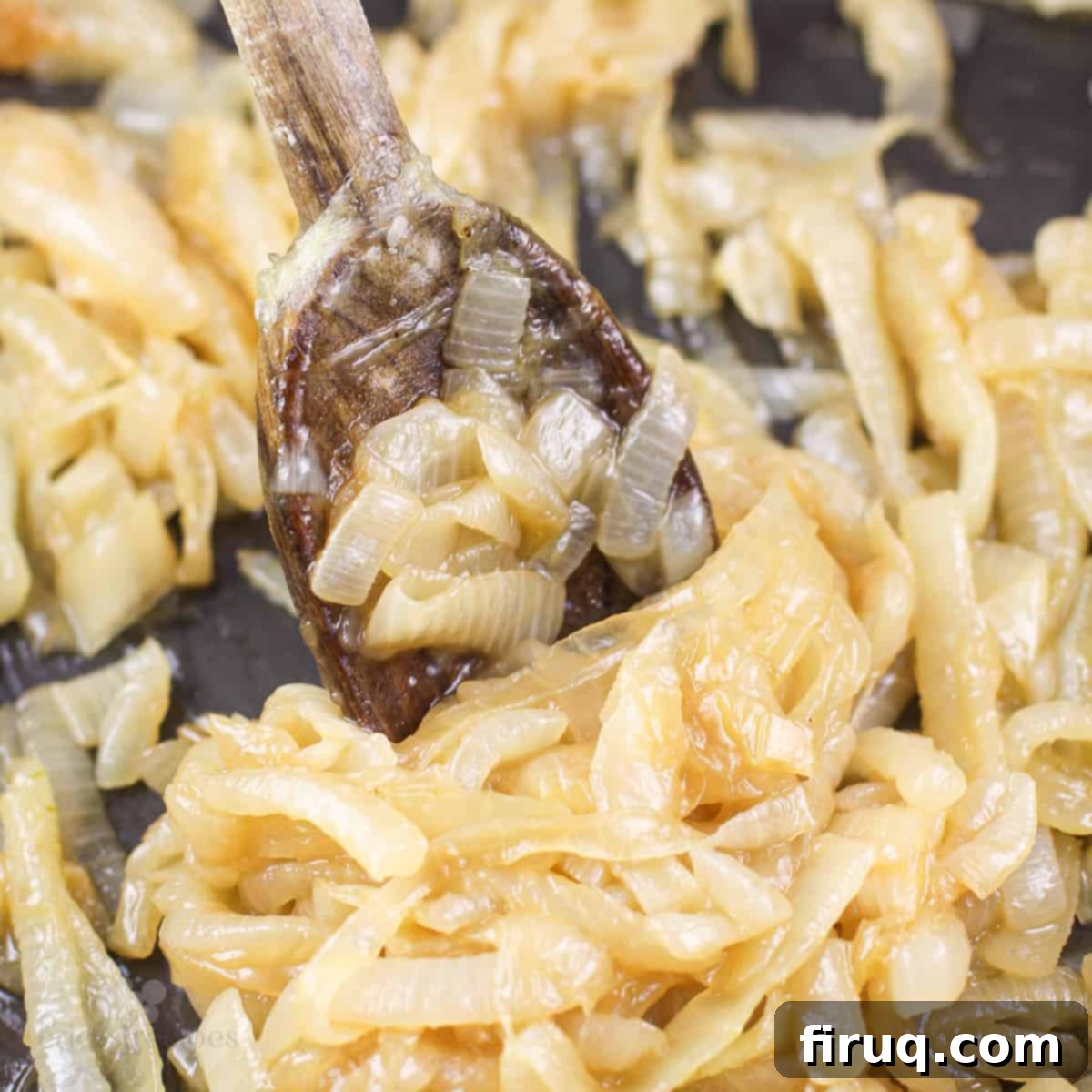 Sticky Honey Bourbon Onions 9 prepared honey bourbon caramelized onions in skillet with wood spoon