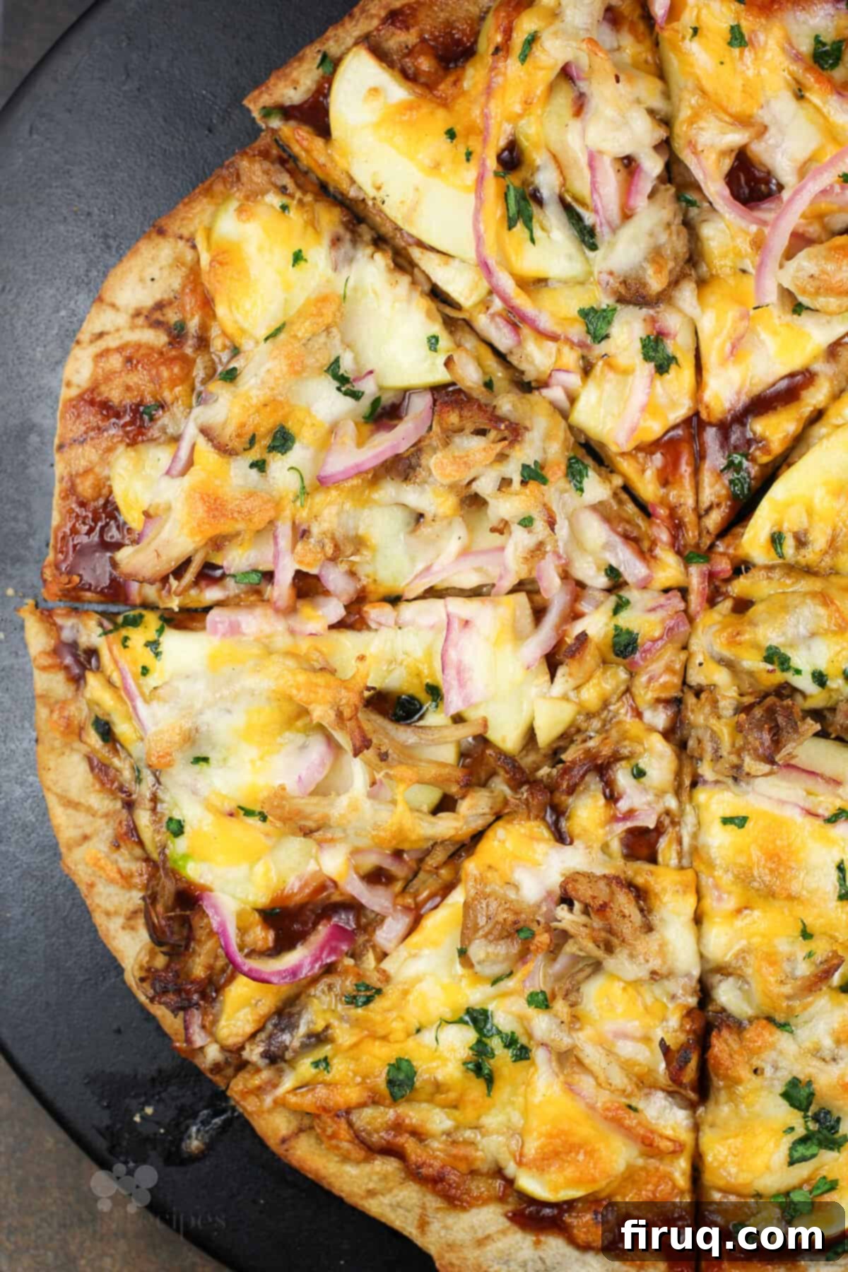 Pulled Pork & Apple Pizza 5 sliced pizza on black pizza stone.