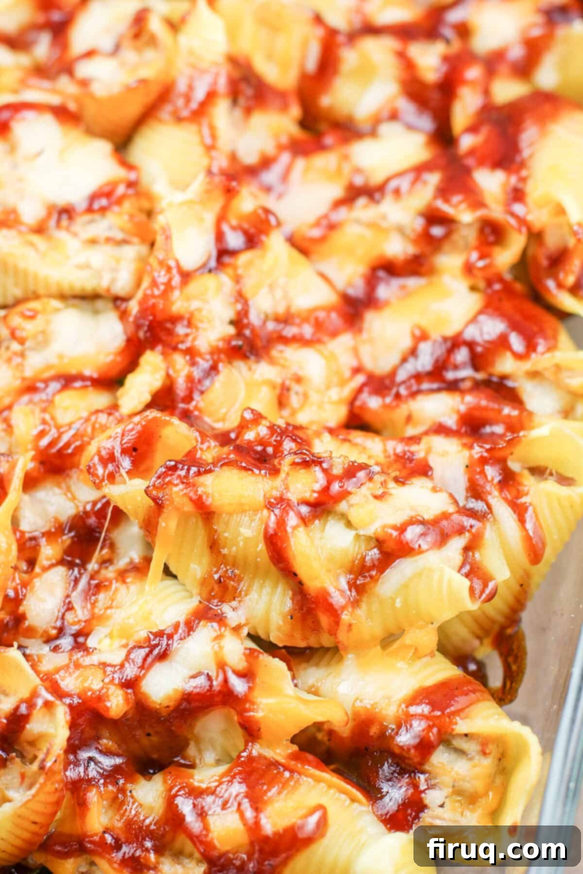 Cheesy BBQ Pulled Pork Stuffed Shells 3 Close-up of three stuffed pasta shells in a baking dish, ready for the oven, showing the cheesy filling.