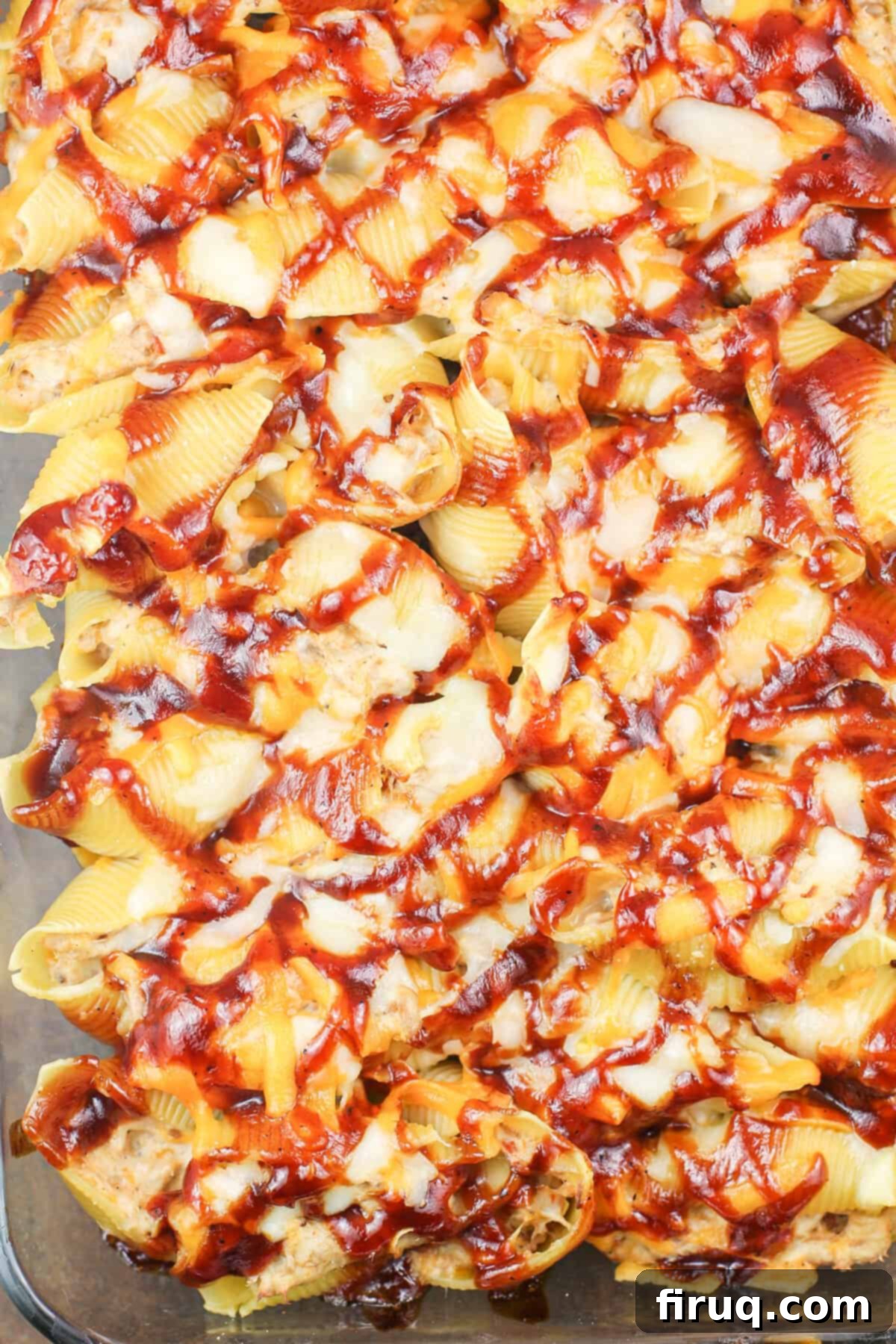 Cheesy BBQ Pulled Pork Stuffed Shells 4 A large baking dish filled with cheesy BBQ pulled pork stuffed shells, freshly baked and ready to serve.