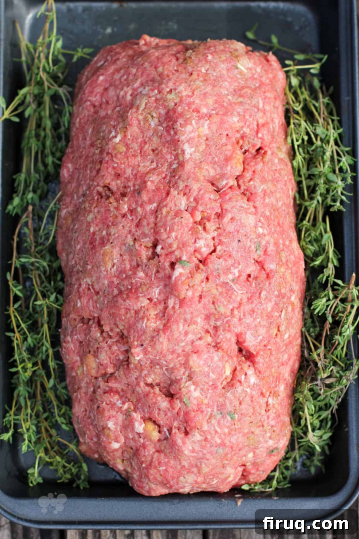 Signature Smoked Meatloaf 4 A formed meatloaf meticulously placed in a metal pan, ready for the smoker, showcasing its raw, seasoned mixture.